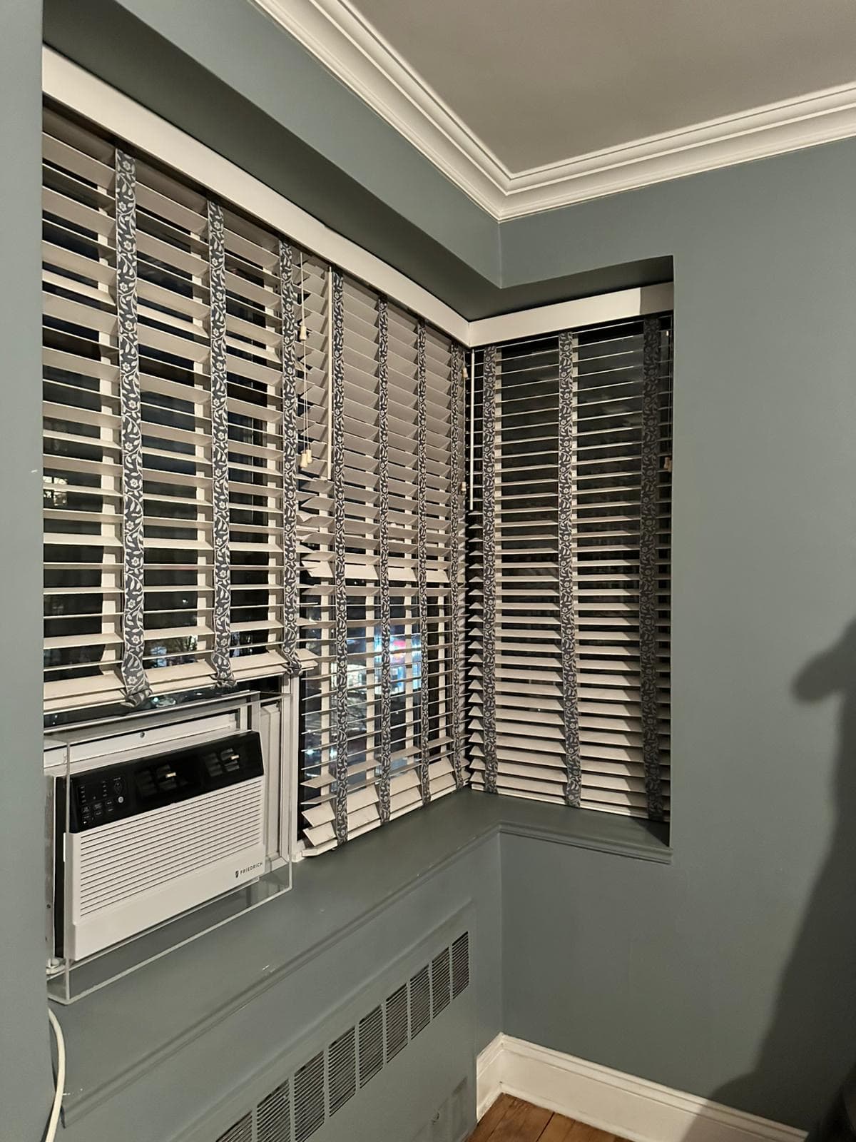 Interior insulation panels fitted behind shades at a corner window